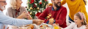 family gathered around a table with a christmas tree in the background